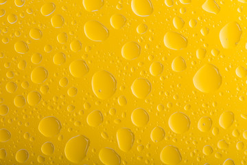 Clear yellow water drops over yellow background