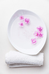 Fototapeta na wymiar Flowers in white bowl with sea ​​salt for SPA