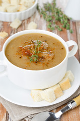 Mushroom cream soup with croutons and thyme in a bowl vertical