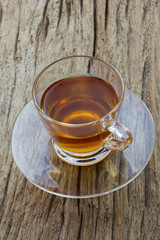 glass cup of tea on wood background, top view