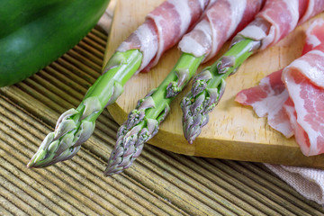 Bacon and asparagus on a wooden background