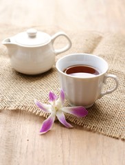 cup of tea with orchid flower on wooden table