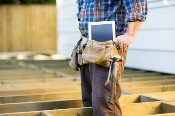 Construction Worker With Tablet Computer And Hammer In Toolbelt