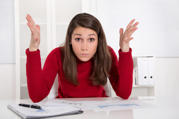 Hilflose junge Frau im Büro - gestresst und frustriert