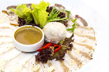 sliced bacon with sauce and greens