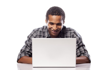 happy and smiling dark-skinned student working on his laptop