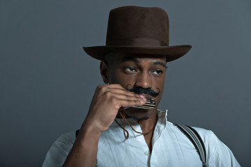 Harmonica playing retro afro america western cowboy man with mus