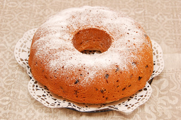 Round homemade biscuit cake on plate and napkin