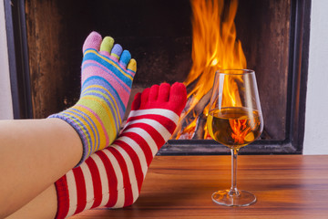  relaxing at fireplace in colorful funny toesocks - obrazy, fototapety, plakaty