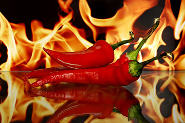 Red chili peppers. Sharp red siliculose pepper against a flame.