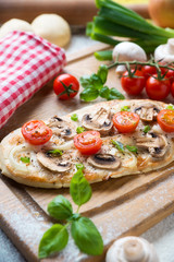 Mini-Pizza mit Champignons und Tomaten