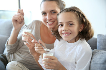 Mother and daughter eating yoghurt