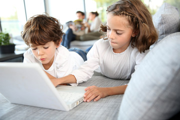 Kids playing with laptop computer at home