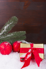 Weihnachtsgeschenk mit roter Schleife im Schnee