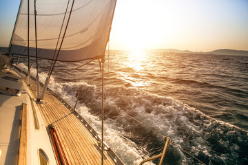 Yacht sailing during sunset. Luxury yachts.
