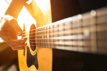 Naklejka premium Female hand close-up playing on acoustic guitar.