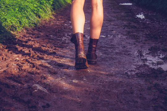 Young woman walking along muddy trail