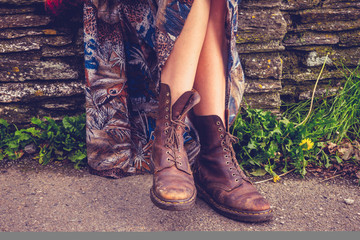 Woman's legs and hiking boots by stone wall