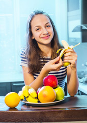 Obraz premium Beautiful Young Woman choosing between Fruits and Sweets