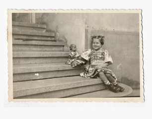 Little girl with doll on the stairs - circa 1950 - 57851720