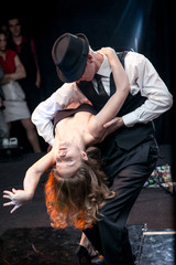 Sexy young couple dancing argentinian tango on stage