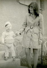 Fototapeta na wymiar Young mother with her son - circa 1973