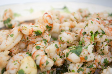 close up macro focus on prawns in olive oil with a parsley seaso