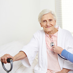 Seniorin wird mit Stethoskop abgehört