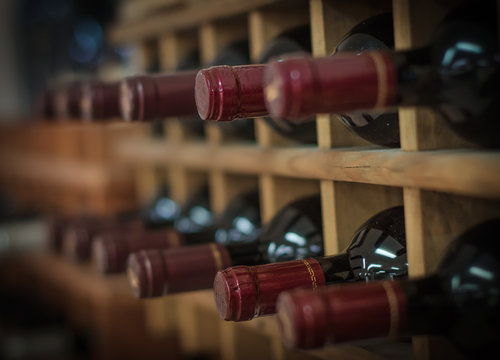 Red wine bottles stacked on wooden racks