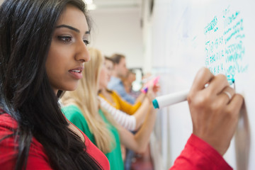 Students writing on the whiteboard in class