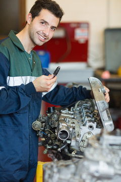 Happy repairman repairing an engine