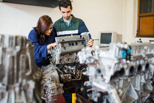 Trainee and instructor repairing an engine