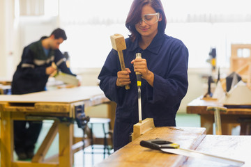 Trainee using mallet and chisel