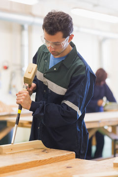 Carpenter using mallet and chisel