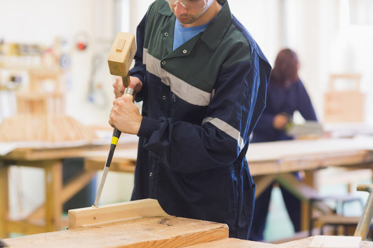 Craftsman using mallet and chisel
