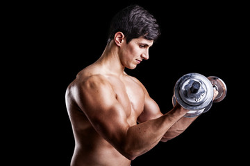 Portrait of a strong man lifting weights against a dark backgrou