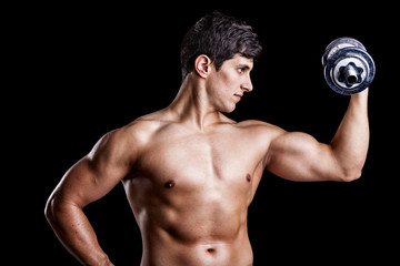 Fototapeta na wymiar Portrait of a strong man lifting weights against a dark backgrou