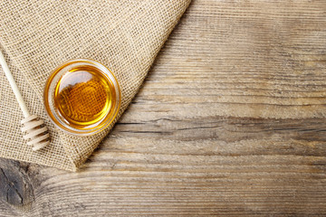 Bowl of honey on wooden table. Symbol of healthy living