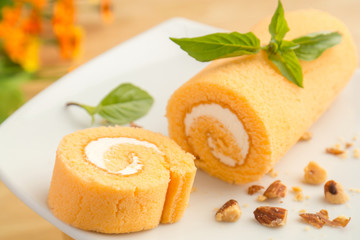 Orange roll cake on white plate