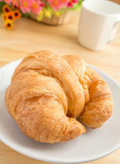Closeup of a croissant with coffee cup