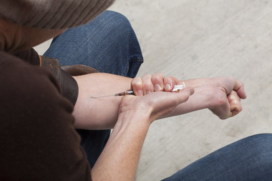 Junkie with a needle in his hand