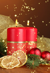 Two candles and Christmas decorations, on wooden background