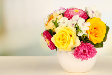 Beautiful bouquet of bright flowers in color vase,