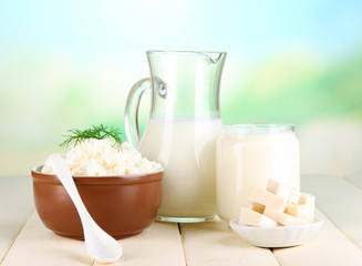 Fresh dairy products on wooden table on natural background