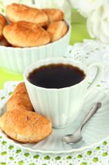 Tasty croissants and cup of coffee on table close-up