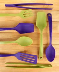 Plastic kitchen utensils on wooden background