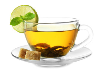 Transparent cup of green tea with lime and sugar isolated