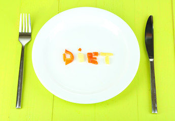 Word diet lined vegetables on plate on wooden table close-up