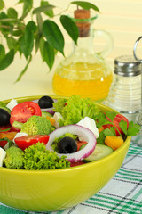 Greek salad on plate on table on light background