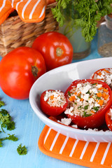 Stuffed tomatoes in bowl on wooden table close-up